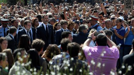 Le roi d'Espagne Felipe VI (à gauche), le Premier ministre espagnol Mariano Rajoy (au centre) et le président du gouvernement catalan, Carles Puigdemont (à droite), attendent côte à côte avant d'observer une minute de silence sur la Place de Catalogne (Espagne), le 18 août 2017, en hommage aux victimes des attentats perpétrés la veille en Catalogne.&nbsp; (LLUIS GENE / AFP)