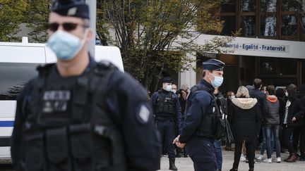 Des policiers en faction devant le collège du Bois d'Aulne à Conflans-Sainte-Honorine où enseignait Samuel Paty. (ARNAUD DUMONTIER / MAXPPP)