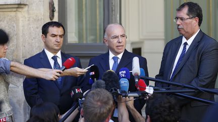 Bernard Cazeneuve entouré d'Ahmet Ogras et d'Anouar Kbibech, deux responsables du CFCM, le 24 août &nbsp;2016. (MATTHIEU ALEXANDRE / AFP)