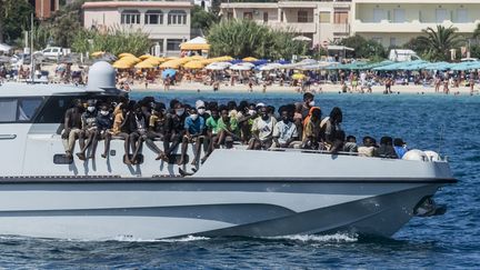 Des migrants arrivent sur un navire dans le port de l'île italienne de Lampedusa, le 15 septembre 2023. (ALESSANDRO SERRANO / AFP)