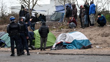 Des policiers et un groupe de migrants à Calais, dans le nord de la France, le 28 Novembre 2019. (DENIS CHARLET / AFP)