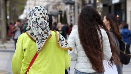 Une femme voilée sur les Champs-Élysées, à Paris. (DELPHINE GOLDSZTEJN / MAXPPP)