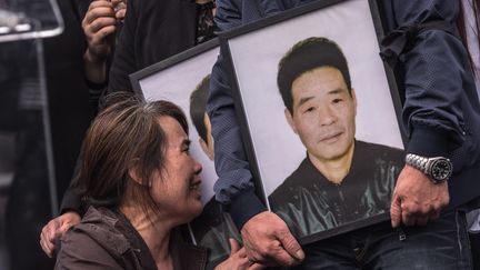 La veuve de Liu Shaoyao pleure devant le portrait de son mari durant une manifestation place de la République, à Paris, le 2 avril 2017. (JULIEN MATTIA / NURPHOTO / AFP)