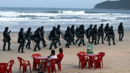 Des policiers patrouillent sur la plage Santinho dans le cadre des op&eacute;rations de s&eacute;curit&eacute; mises en place pour la Coupe du monde de football, Florianopolis (Br&eacute;sil), le 19 f&eacute;vrier 2014. (SERGIO MORAES / REUTERS)