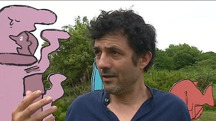 Albin de la Simone devant les figures dessinées par Jean Julien (K. Hannedouche /France Télévisions)