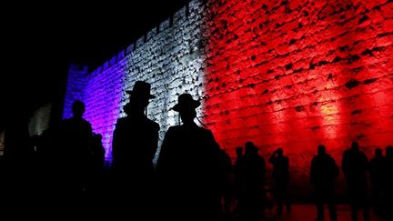 Des religieux orthodoxes le long du Mur des Lamentations éclairé aux couleurs de la France, en hommage aux victimes des attentats de Paris. (Ammar AWAD / AFP)