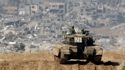 Des soldats israéliens face à des immeubles ravagés de la bande de Gaza, le 19 janvier 2024. (JACK GUEZ / AFP)