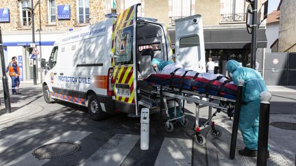 Des membres de la protection civile emmène un patient à bord d'une ambulance, le 18 avril 2020 à Poissy, en région parisienne. (ANTOINE KREMER / HANS LUCAS / AFP)