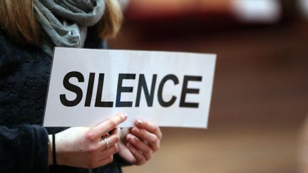 Un&nbsp;personne tient une pancarte "silence" pendant les rencontres&nbsp;européenns de Taizé, le 3 juillet 2018, à Basel (Suisse).&nbsp; (GODONG / AFP)