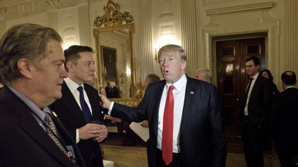 Elon Musk is flanked by Steve Bannon and Donald Trump at the White House in Washington on February 3, 2017. (Brandon Smyalowski/AFP)