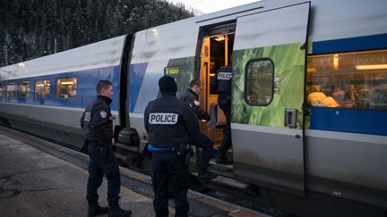 Des&nbsp;officiers de police français embarquent dans un train en direction de Paris, le 12 janvier 2018 en gare de Bardonecchia (Italie). (PIERO CRUCIATTI / AFP)