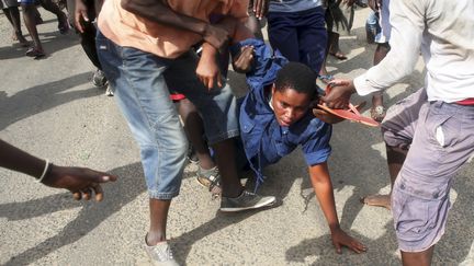 Une femme polici&egrave;re attaqu&eacute;e pr les manifestants dans le quartier de&nbsp;Buterere, &agrave; Bujumbura (Burundi), le 12 mai 2015. (GORAN TOMASEVIC / REUTERS )