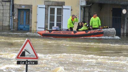 Des membres des secours viennent en aide &agrave; une habitante de Quimperl&eacute; (Finist&egrave;re) alors que la ville est sous les eaux, le 7 f&eacute;vrier 2014. (FRANK PERRY / AFP)