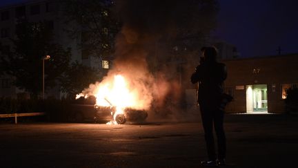 Une voiture incendi&eacute;e dans la banlieue de Stockholm (Su&egrave;de),&nbsp;le 21 mai 2013. (JONATHAN NACKSTRAND / AFP)