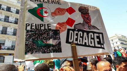 Un manifestant algérien brandit une pancarte sur laquelle on inflige au&nbsp;chef de l'armée, Ahmed Gaïd Salah, un carton rouge (exclusion au football), à Alger, le 12 juillet 2019. (- / AFP)