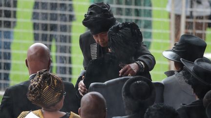 Winnie Madikizela-Mandela et Gra&ccedil;a Machel, deux ex-&eacute;pouses de Nelson Mandela, s'embrassent, le 10 d&eacute;cembre 2013, lors de l'hommage rendu au prix Nobel de la paix, &agrave;&nbsp;Johannesburg (Afrique du Sud). (CHRISTOPHER FURLONG / GETTY IMAGES EUROPE / AFP)