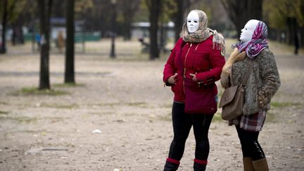 Deux prostitu&eacute;es masqu&eacute;es manifestent contre la loi discut&eacute;e &agrave; l'Assembl&eacute;e nationale, aux&nbsp;Invalides, &agrave; Paris, le&nbsp;29 novembre 2013. (JOEL SAGET / AFP)