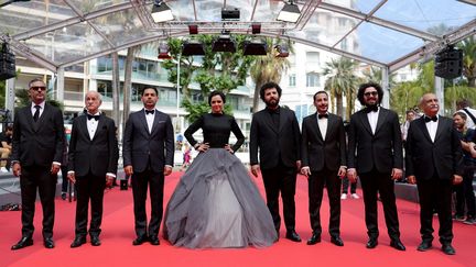 L'équipe du film "Leila's brothers" sur le tapis rouge. L'actrice principale, l'iranienne Taraneh Alidoosti, est au centre, les mains sur les hanches, dans une robe longue et bouffante.&nbsp; (VALERY HACHE / AFP)