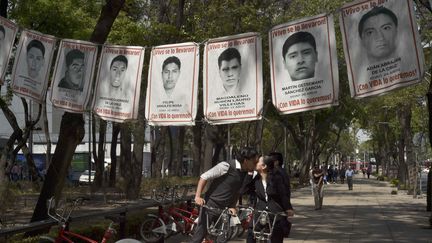 Des portraits des 43 étudiants disparus sont accrochés au-dessus d'une rue,&nbsp;à Mexico, le 14 avril 2016. (YURI CORTEZ / AFP)