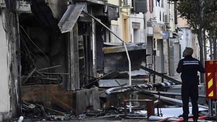 Un gendarme devant l'immeuble où a eu l'explosion, le 15 février 2022, à Saint-Laurent-de-la-Salanque, dans les Pyréenes-Orientales. (RAYMOND ROIG / AFP)