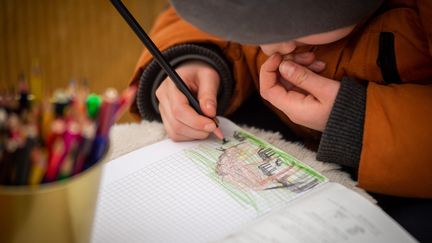 Un enfant ukrainien&nbsp;dessine dans un camp de réfugiés&nbsp;à la frontière avec la Slovaquie, le 9 mars 2022. (PETER LAZAR / AFP)