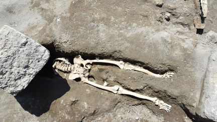 Le squelette d'un homme décapité par un bloc de pierre est excavé sur le site archéologique de Pompéi, en Italie, le 30 mai 2018. (PARQUE ARQUEOLOGICO DE POMPEYA / NOTIMEX / AFP)