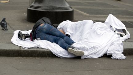 Des sans-abri dorment sur un trottoir, rue de Rivoli, dans le centre de Paris, le 2 avril 2015.&nbsp; (KENZO TRIBOUILLARD / AFP)