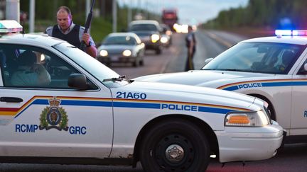 Des v&eacute;hicules de police maintiennent un p&eacute;rim&egrave;tre de s&eacute;curit&eacute; apr&egrave;s une fusillade &agrave; Moncton, dans l'est du Canada, le 4 juin 2014. (MARC GRANDMAISON / AP / SIPA)