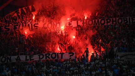 Des supporters marseillais tendent une bannière avec des messages contre l'homophobie pendant un match de Ligue 1 de foot, le 1er septembre 2019. (CHRISTOPHE SIMON / AFP)