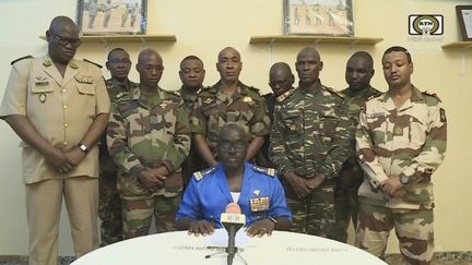 Sur cette capture d’écran d’une vidéo fournie par la chaîne publique nigérienne ORTN, le colonel major Amadou Abdramane (au centre), annonce sa prise de pouvoir du pays, le 26 juillet 2023, à Niamey. (ORTN / AFP)