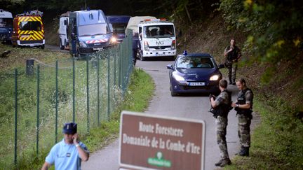 Encadr&eacute;e par des gendarmes, une d&eacute;panneuse emporte la voiture dans laquelle quatre personnes ont &eacute;t&eacute; tu&eacute;es &agrave; Chevaline, en Haute-Savoie, le 6 septembre 2012. (PHILIPPE DESMAZES / AFP)