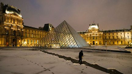 Les abords de la pyramide du Louvre, à Paris, recouverts de neige, au matin du 18 janvier 2024. (DIMITAR DILKOFF / AFP)