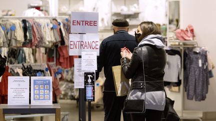 Une femme à l'entrée d'un magasin qui se désinfecte les mains, le 11 mai 2020.&nbsp; (GUILLAUME BONNEFONT / MAXPPP)