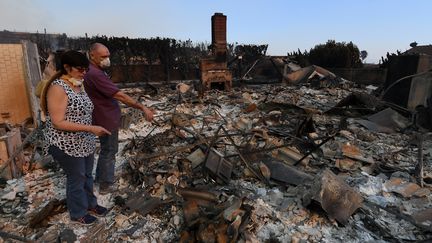 Ces habitants de Ventura, à l'ouest de Los Angeles, n'ont pas pu sauver leur maison des flammes, et explorent ses décombres carbonisés par l'incendie "Thomas", le 6 décembre 2017. (MARK RALSTON / AFP)