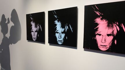 Trois des "Six autoportraits" d'Andy Warhol en vente chez Sotheby's à New York en mai 2014. Warhol est la star absolue des enchères en 2014.
 (Emmanuel Dunand / AFP)