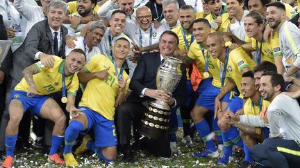 Le président brésilien Jair Bolsonaro au milieu des footballeurs brésiliens vainqueurs de la Copa America, le 7 juillet 2019, au stade Maracana de Rio de Janeiro (Brésil). (CARL DE SOUZA / AFP)