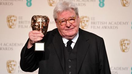 Le cinéaste Alan Parker pose avec son Bafta à Londres, le 10 février 2013. (CARL COURT / AFP)