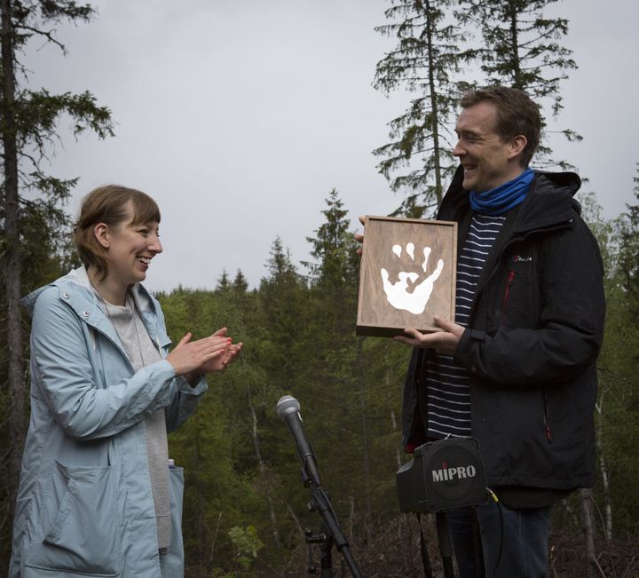 L'auteur David Mitchell (à droite) remet son manuscrit à l'artiste Katie Paterson, le 28 mai 2016, dans la forêt de Nordmarka (Norvège). (KRISTIN VON HIRSCH / BJORVIKA UTVIKLING)
