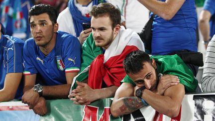 Quand on est aux bords des larmes, à l'image de ces trois Italiens défaits, on regarde n'importe où mais surtout pas sur le terrain où les adversaires , en l'occurence les Allemands, célèbrent leur victoire. (MICHAEL ZEMANEK / BACKPAGE IMAGES LTD / AFP)