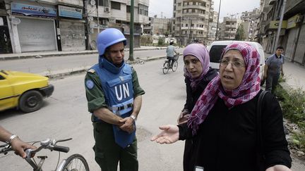 Le chef des observateurs de l'ONU en Syrie, le colonel marocain&nbsp;Ahmed Himmiche, avec des habitants de la ville de Homs, le 3 mai 2012. (JOSEPH EID / AFP)