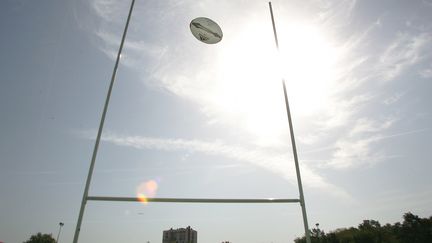 Un ballon de rugby passe entre les poteaux sur un terrain. (BORIS HORVAT / AFP)