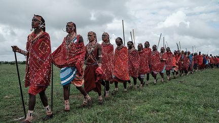 Leurs corps et leurs visages parés de bijoux, les sportifs se rendent en silence sur les lieux des compétitions.&nbsp; (Yasuyoshi CHIBA / AFP)