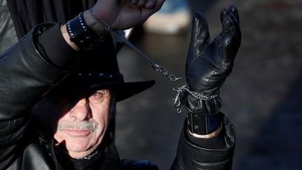 Un fan se présente menotté sur la place de la Concorde, pendant l'hommage populaire. (BENOIT TESSIER / REUTERS)