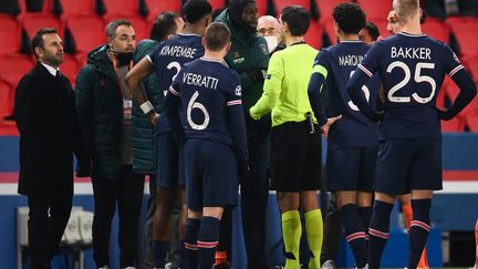 Entouré de joueurs parisiens, Demba Ba demande des explications à l'arbitre après des soupçons d'insultes racistes venues que quatrième arbitre. (FRANCK FIFE / AFP)