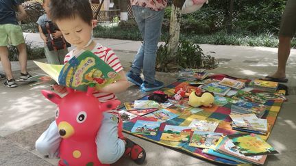 Un enfant joue près d'un marché aux jouets, à Chengdu, en Chine, le 6 juin 2020. (XIAO YI / AFP)