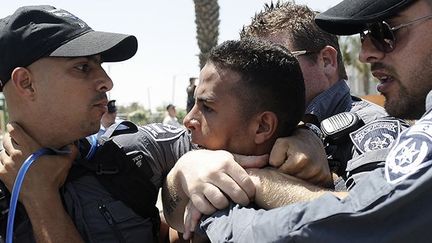 Le 15 juillet 2013 à Beer-Sheva, la principale ville du Néguev (région désertique du sud d'Israël), des policiers israéliens immobilisent un manifestant bédouin. (AFP PHOTO / DAVID BUIMOVITCH)