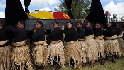 Vêtus de noir et du traditionnel ta'ovala (pagne végétal) ceint à la taille, cent cinquante hommes portent sur trois cents mètres le catafalque jusqu'à la tombe royale. (AFP PHOTO / Torsten BLACKWOOD)