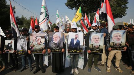 Des manifestants,&nbsp;le 4 janvier 2020,&nbsp;près de la zone verte de Bagdad en Irak, avec&nbsp;des portraits des militaires tués&nbsp;lors de l'assassinat du général&nbsp;Qassem Soleimani. (AHMAD AL-RUBAYE / AFP)