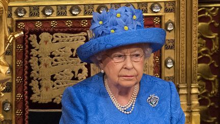 La reine Elizabeth II pour l'ouverture du Parlement, le 21 juin 2017. "La reine est arrivée avec un chapeau, recouvert de marguerites au coeur jaune. Certaines personnes y ont vu le drapeau européen et se sont demandés si la reine n'était pas en train de dire qu'elle était anti-Brexit". Dans son livre, la conseillère en style de la reine, Angela Kelly, a démenti tout caractère politique de ce chapeau.&nbsp; (STEFAN ROUSSEAU / POOL)