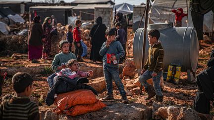 Des volontaires d'une association distribuent de l'aide à des Syriens qui vivent dans des camps de réfugiés, le 23 janvier 2021 à&nbsp;Idlib, en Syrie. (MUHAMMED SAID / ANADOLU AGENCY / AFP)